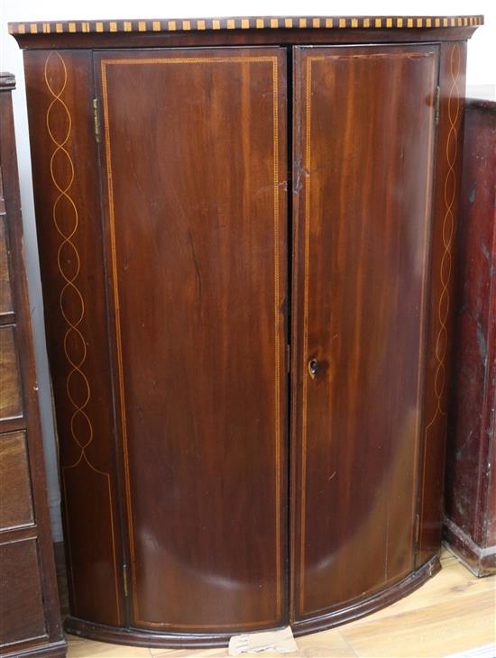 A George III inlaid mahogany bow front hanging corner cupboard W.80cm